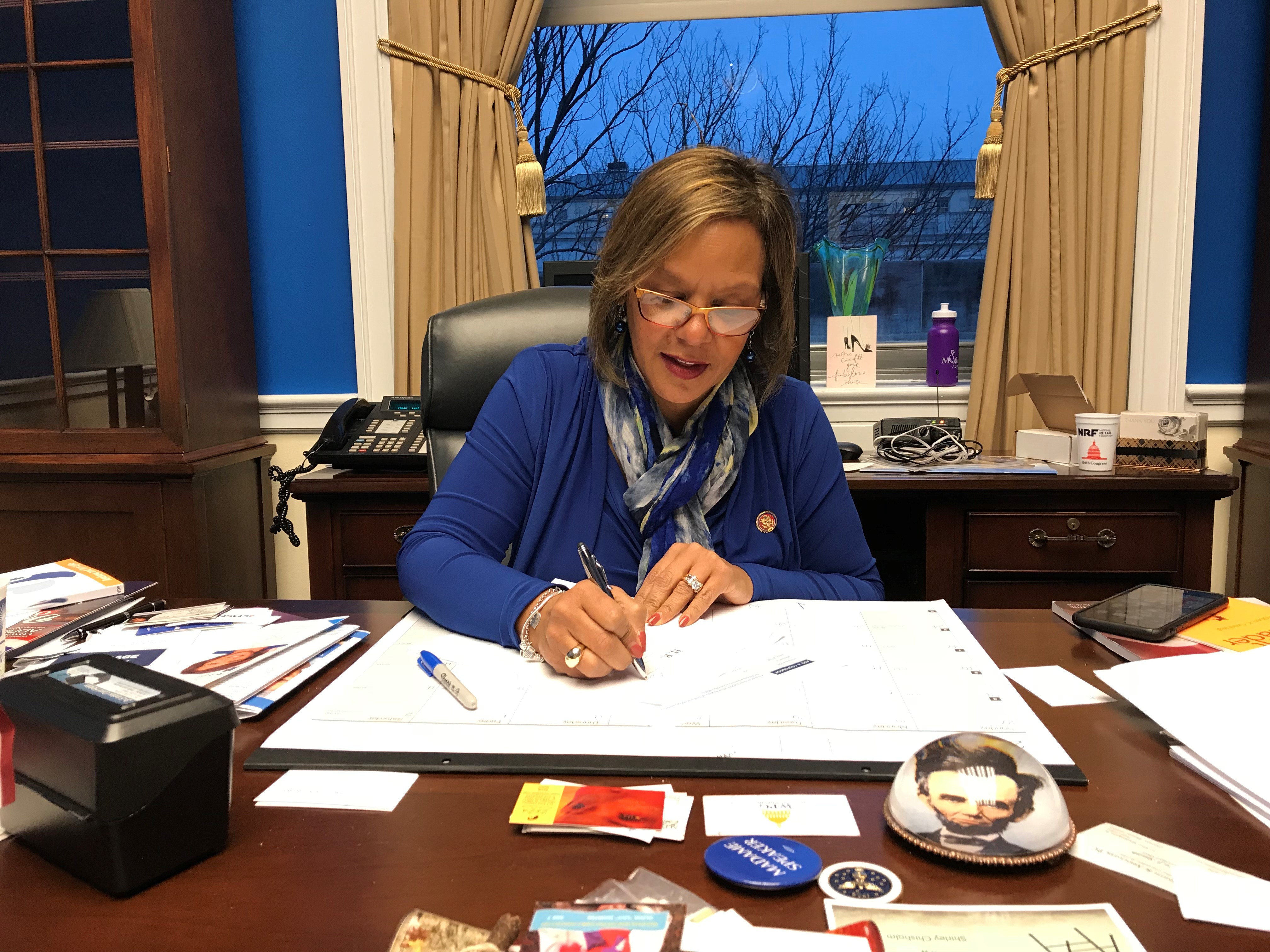 Congresswoman Robin Kelly in her office signing bills