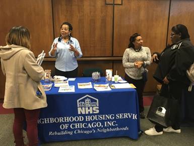 Representatives of Neighborhood Housing Services answer questions about refinancing opportunities